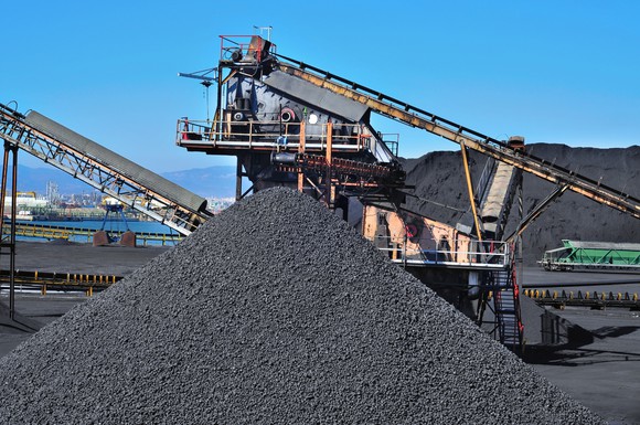 A pile of coal with conveyor belts in the background