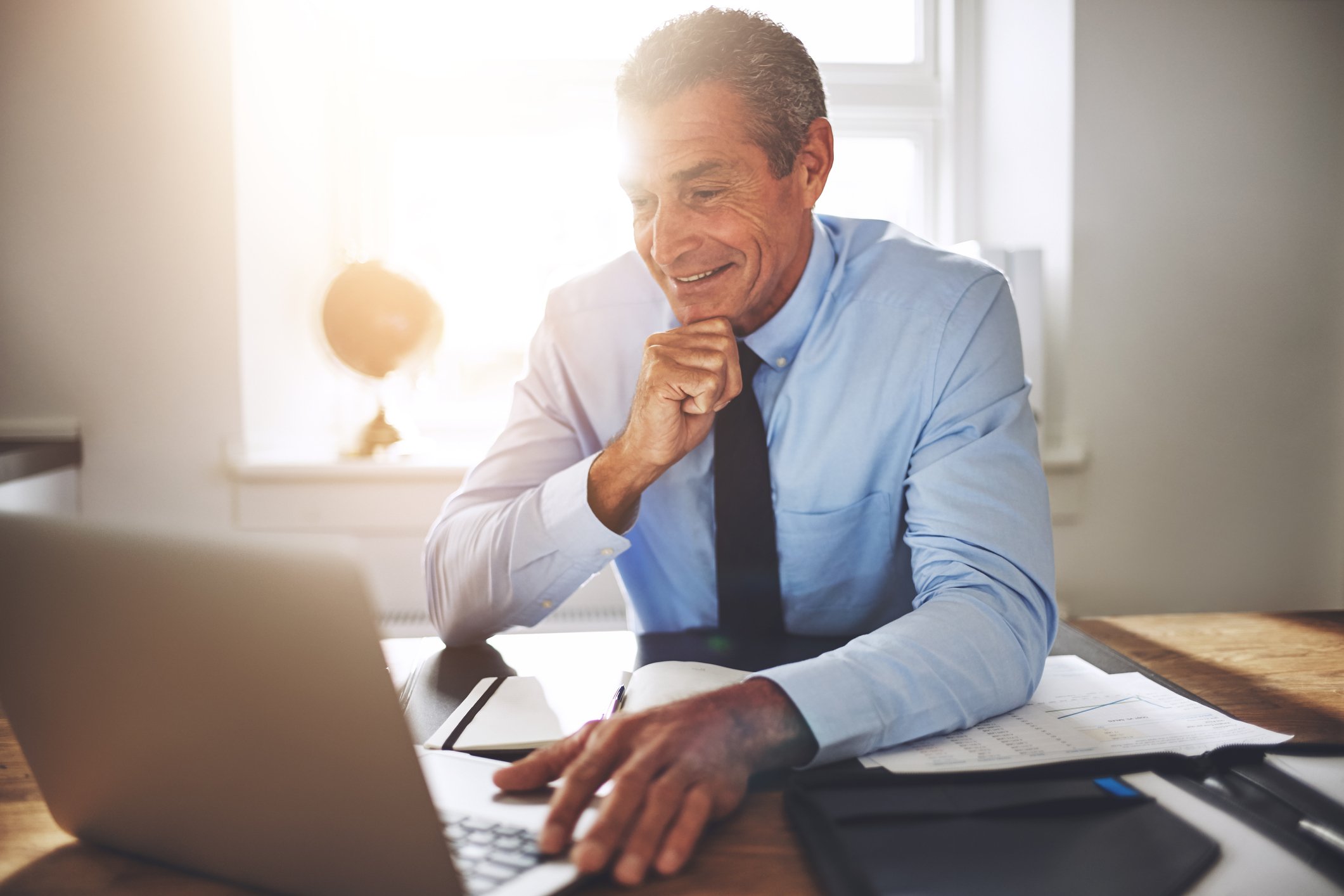 Smiling older man at laptop.