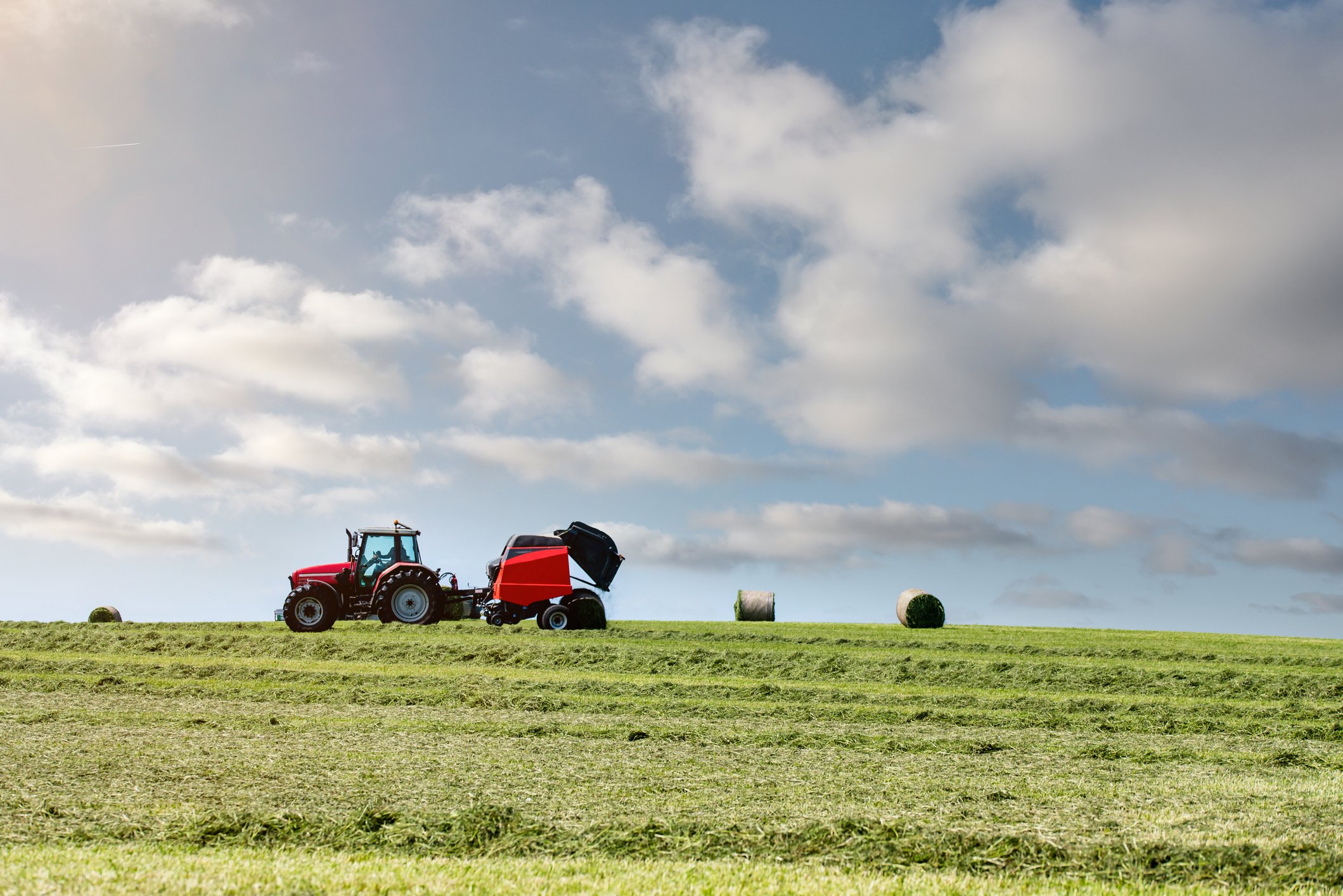 A red tractor is shown on a hill.