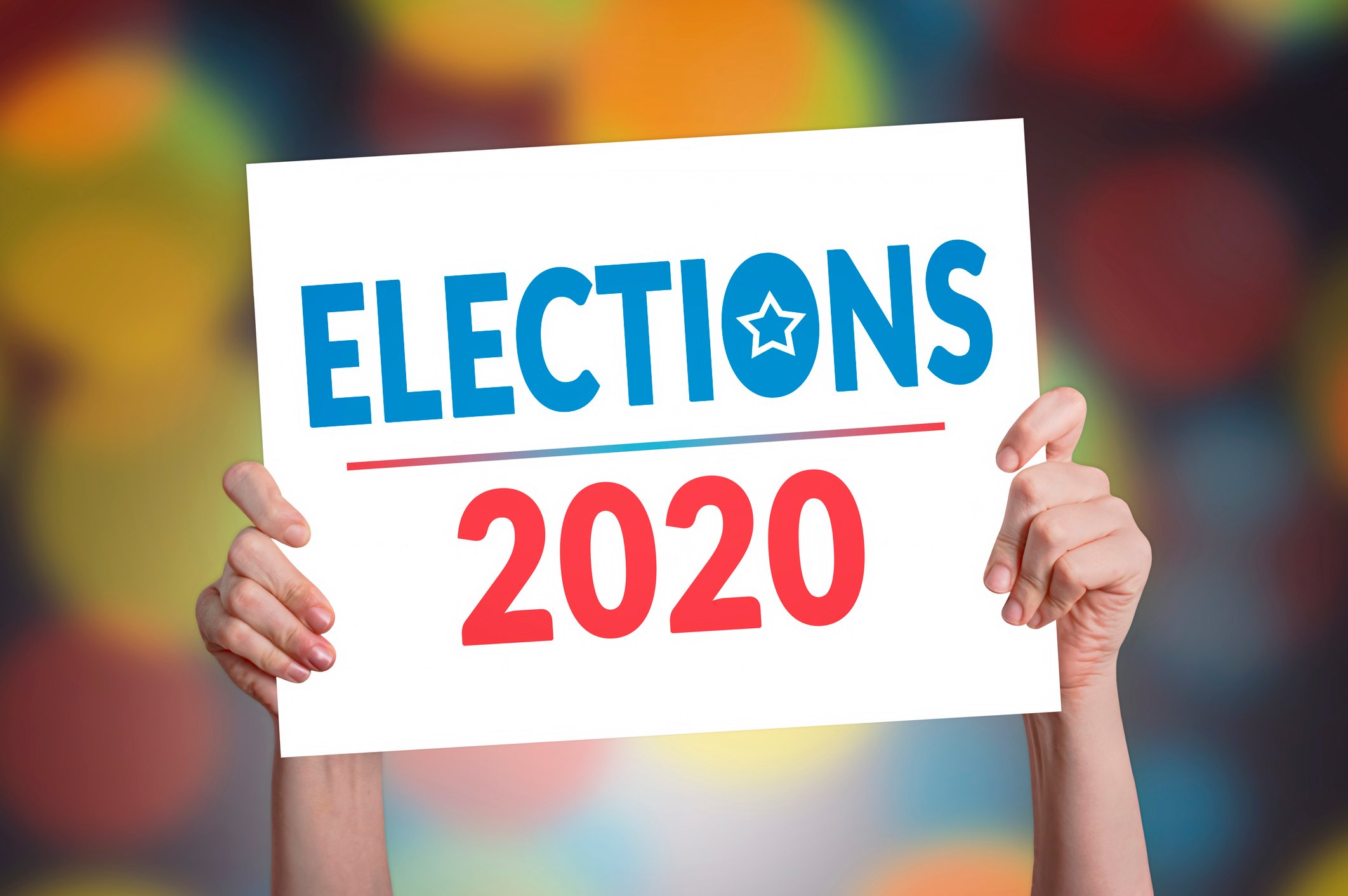 Hands holding up a placard with "Elections 2020" printed on it
