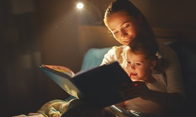 Mother reading book to daughter