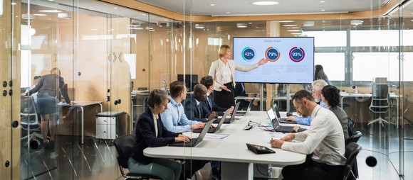 People in a meeting reviewing numbers.