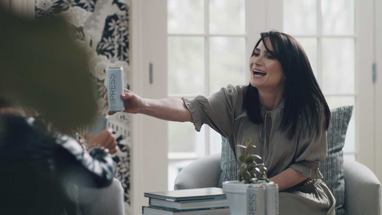 Woman holding can of Press hard seltzer