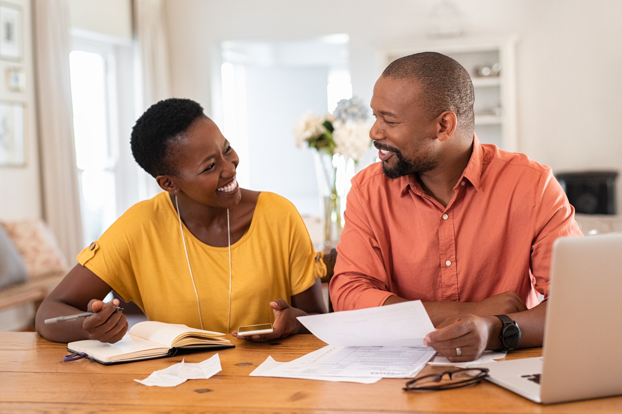 Smiling couple reviewing papers.