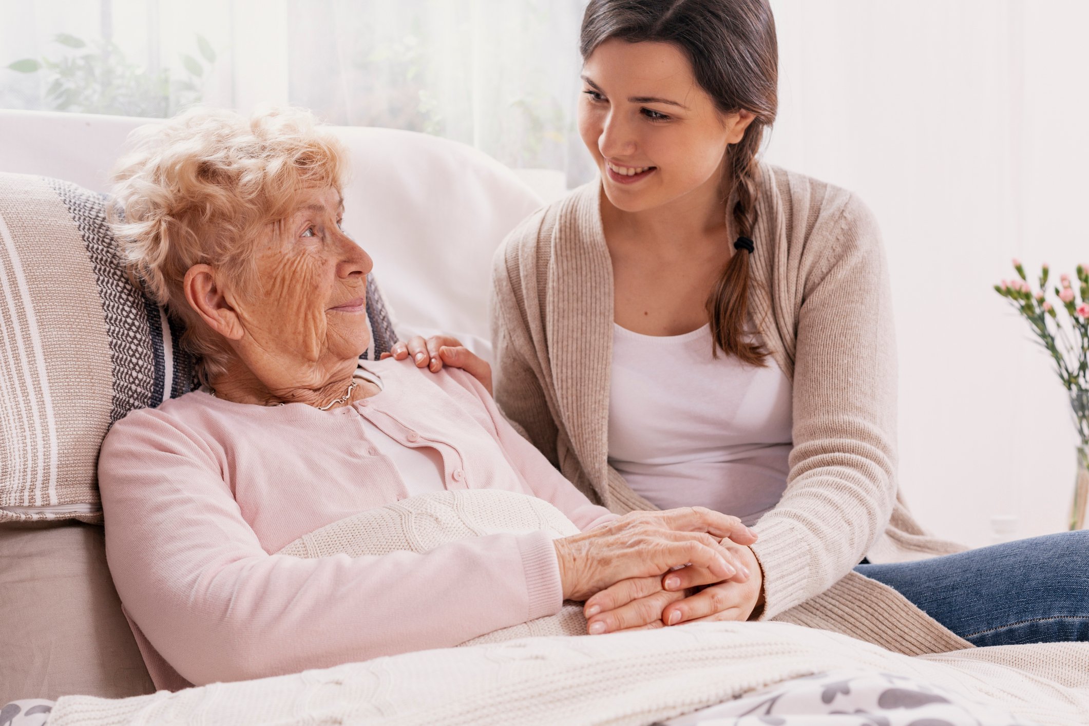 Young woman at the bedside of an Alzheimer's patient.