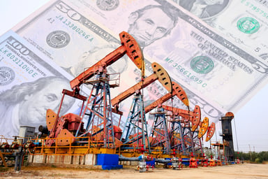 A row of oil pumps with cash in the background.