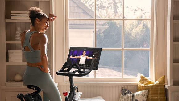 A woman using a Peloton cycle.