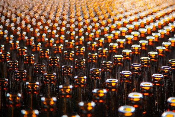 Several rows of brown beer bottles.