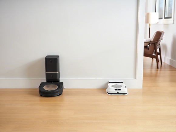iRobot Roomba s9+ and Braava jet M6 docked on a wall near each other.