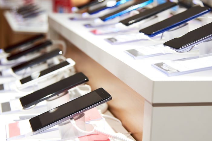 Photograph of smartphones on display in wireless service store.