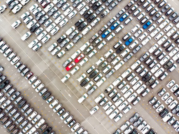 An overhead shot of hundreds of new cars waiting for shipment at a port lot.