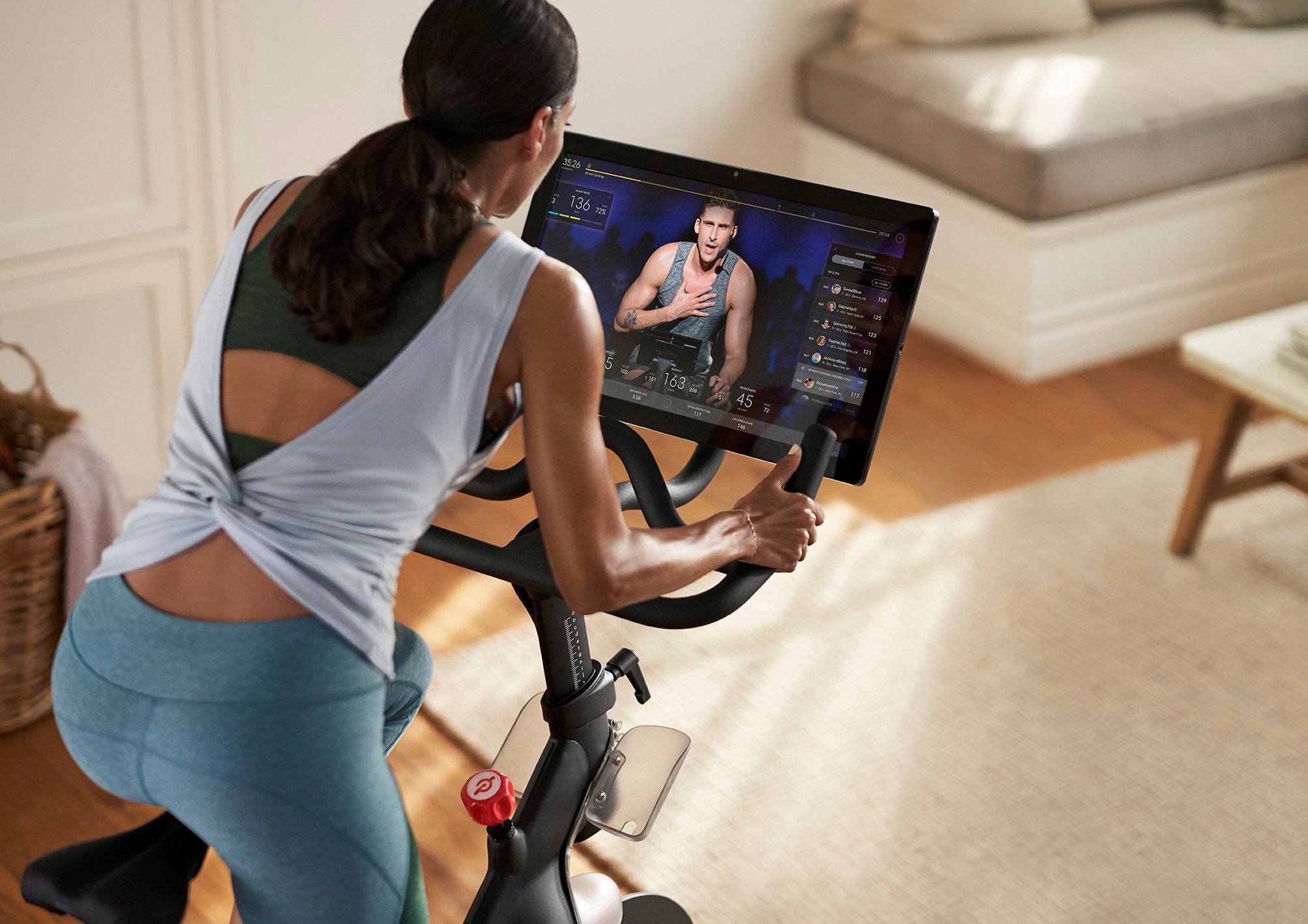 A woman exercising on a Peloton bike.