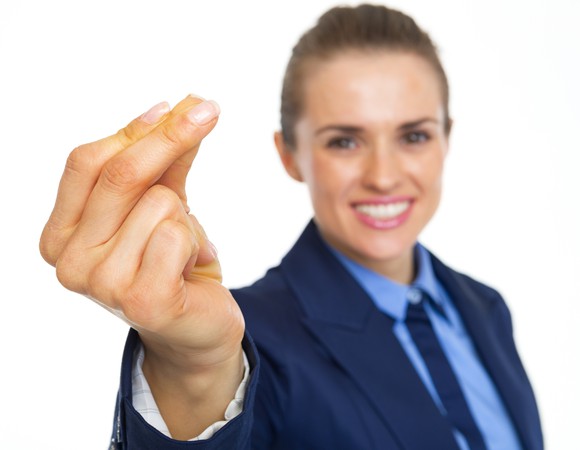 A woman in a suit snaps her fingers at the camera