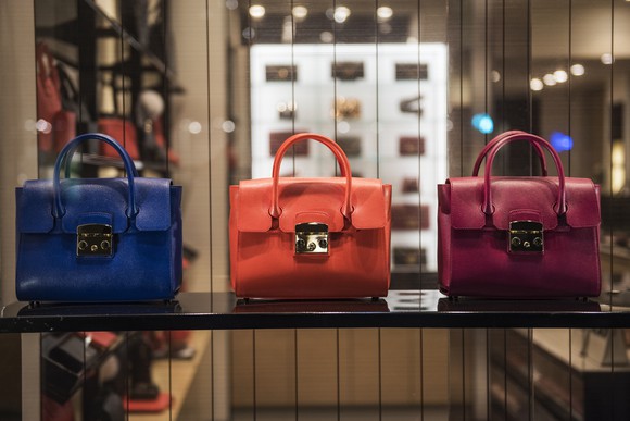 Three luxury handbags in a store window.