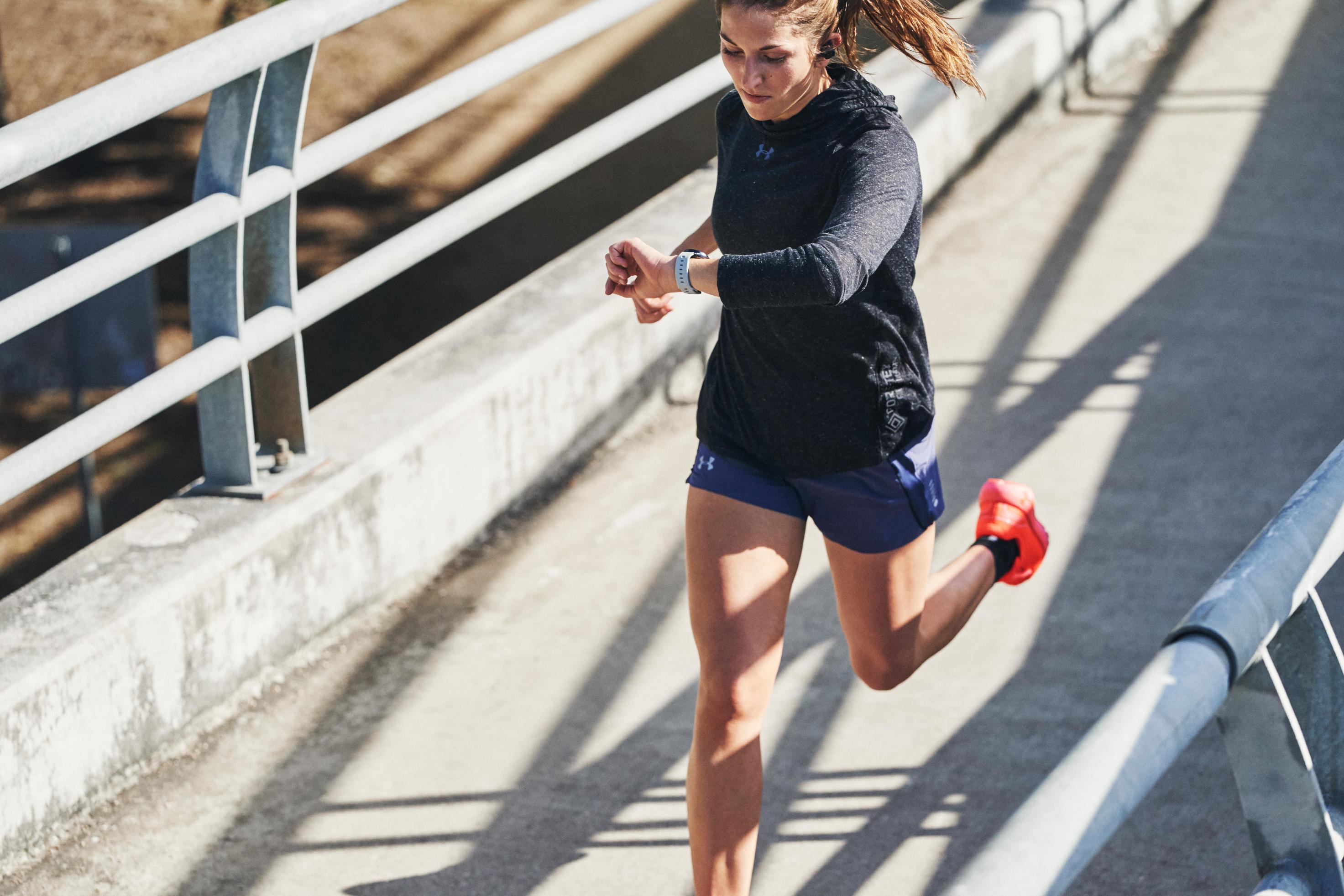 A woman running and wearing apparel from Under Armour.