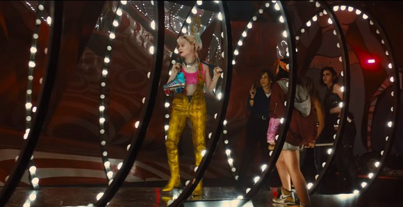 The Birds of Prey team walk down a brightly lit tunnel, led by Margot Robbie as Harley Quinn, in a stillframe from Harley Quinn: Birds of Prey.