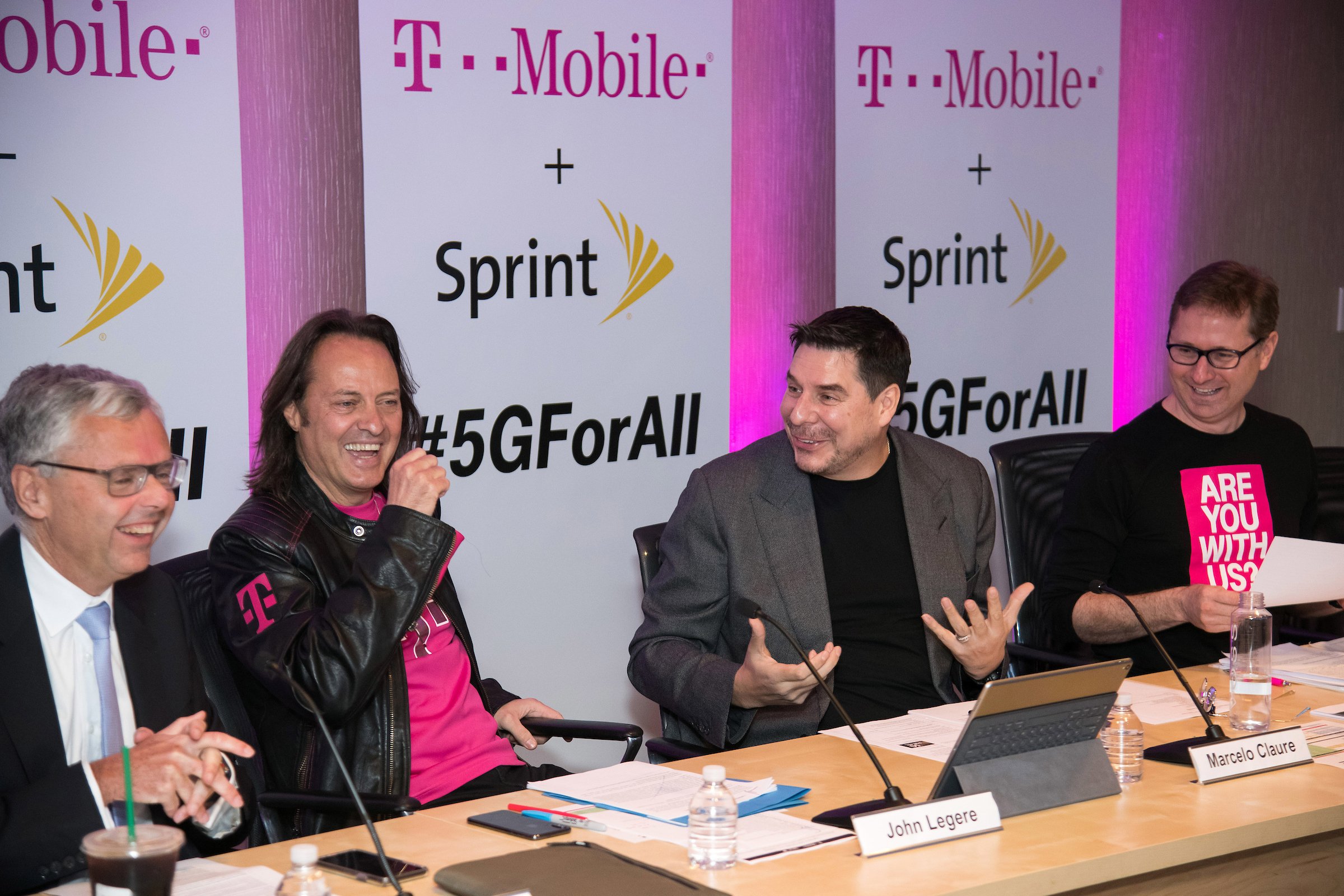 John Legere and Marcelo Claure sitting next to each other laughing