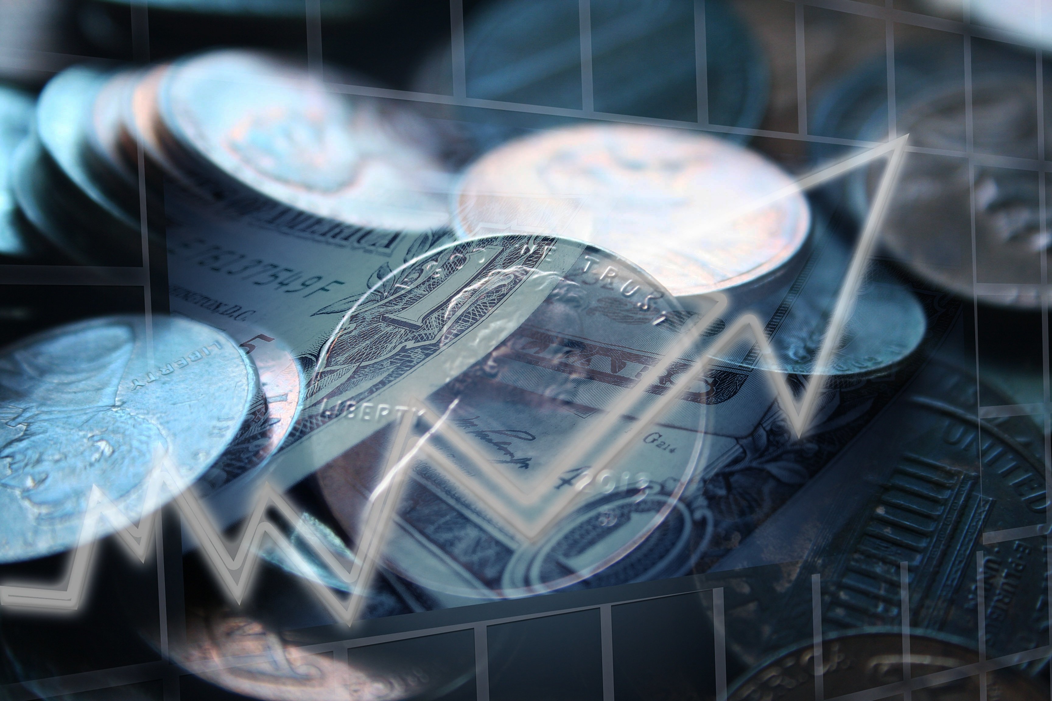 Coins and dollar bills in front of an arrow pointing upward. 