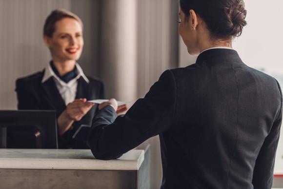 A woman checks into a hotel at the front desk.