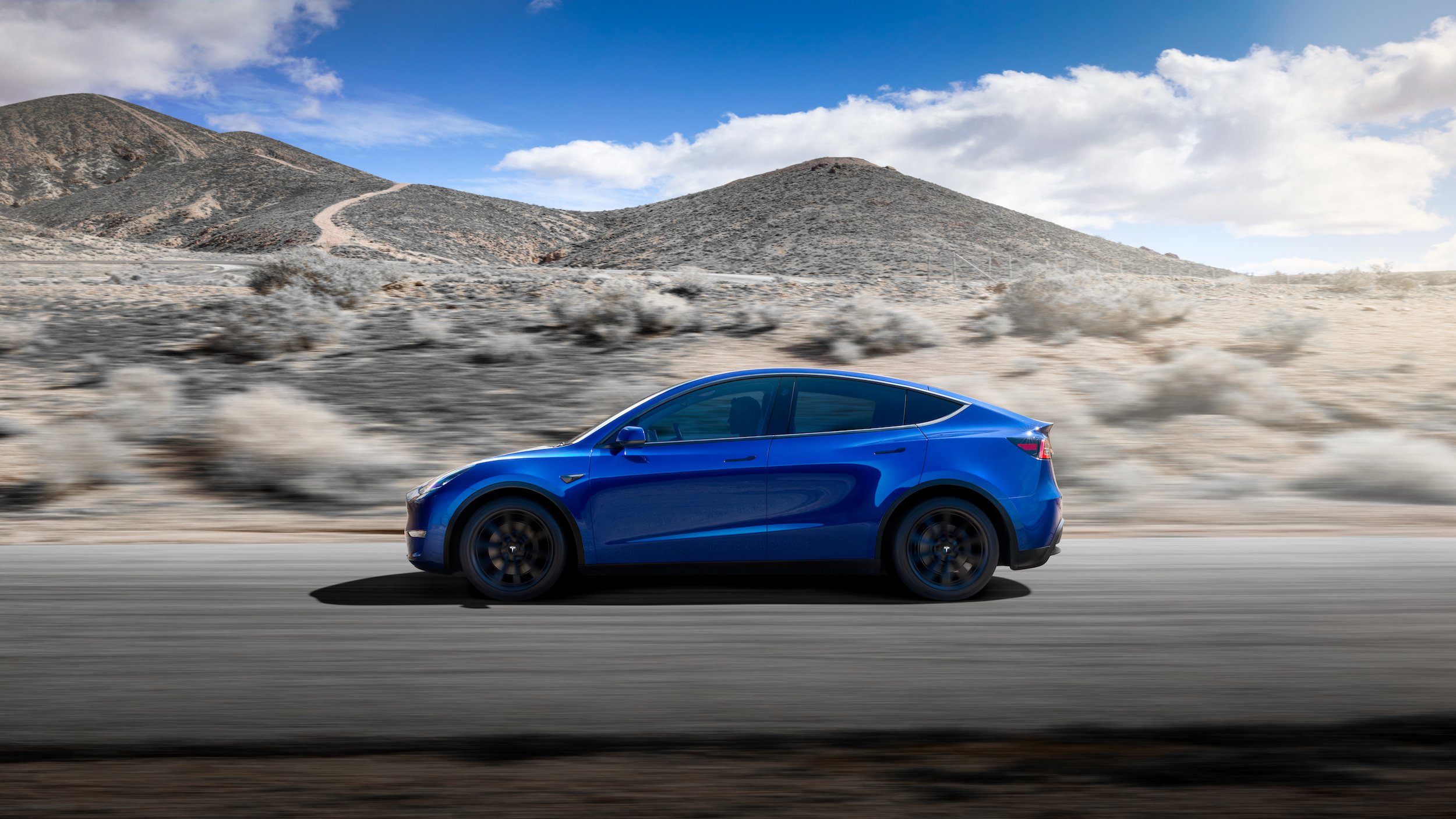 A person driving a blue Tesla Model Y