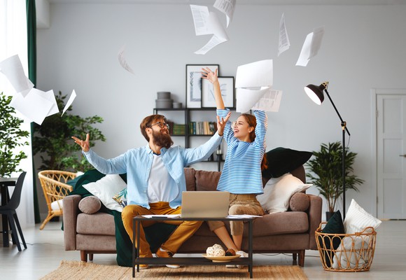 Jubilant couple throwing papers up in the air.