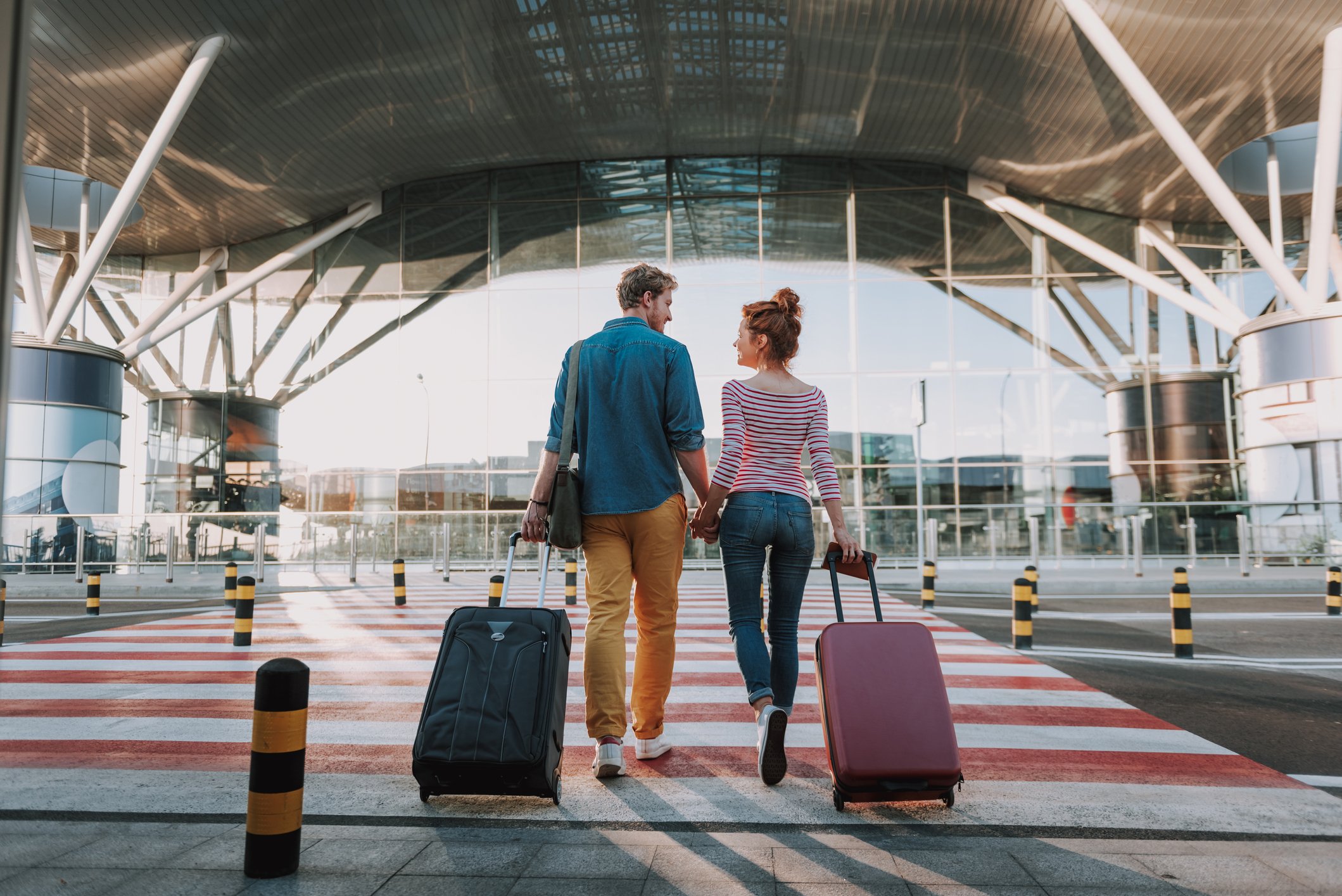 Couple walking to the airport with luggage