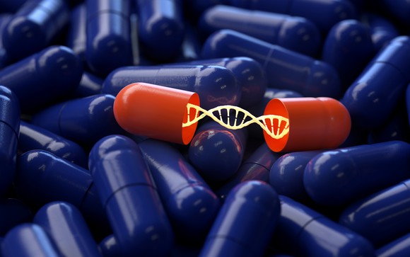 Dozens of blue pills and one open red pill containing a strand of DNA.