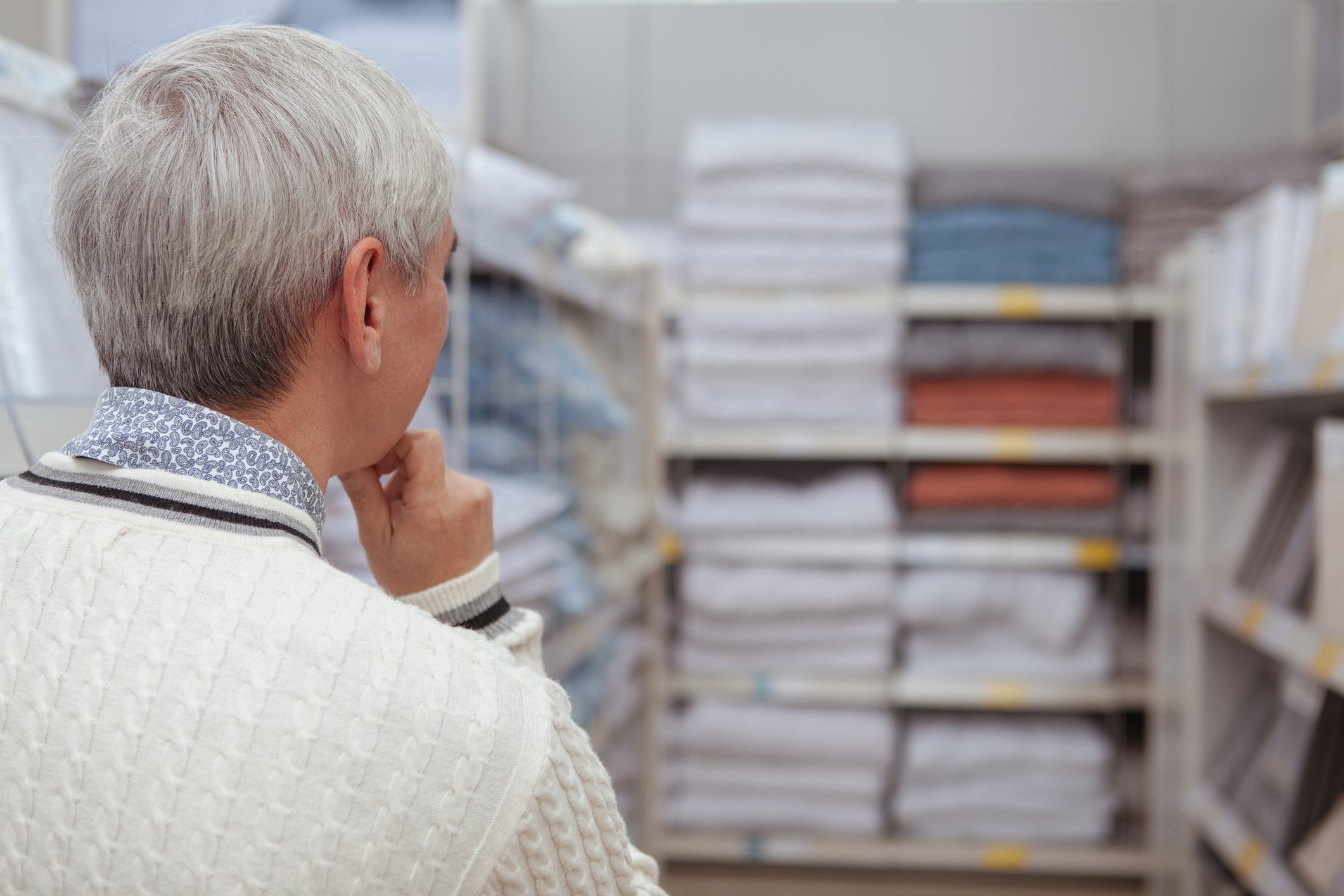 Photograph of woman shopping for bedding, sheets, towels in a home goods store