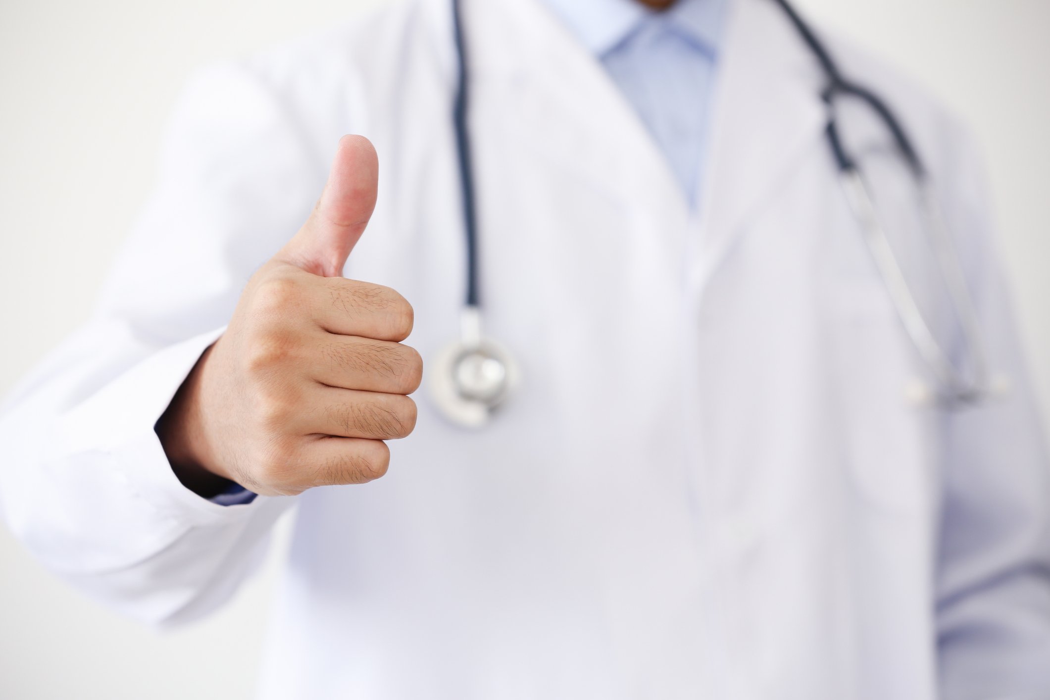 Doctor wearing a lab giving a thumbs-up