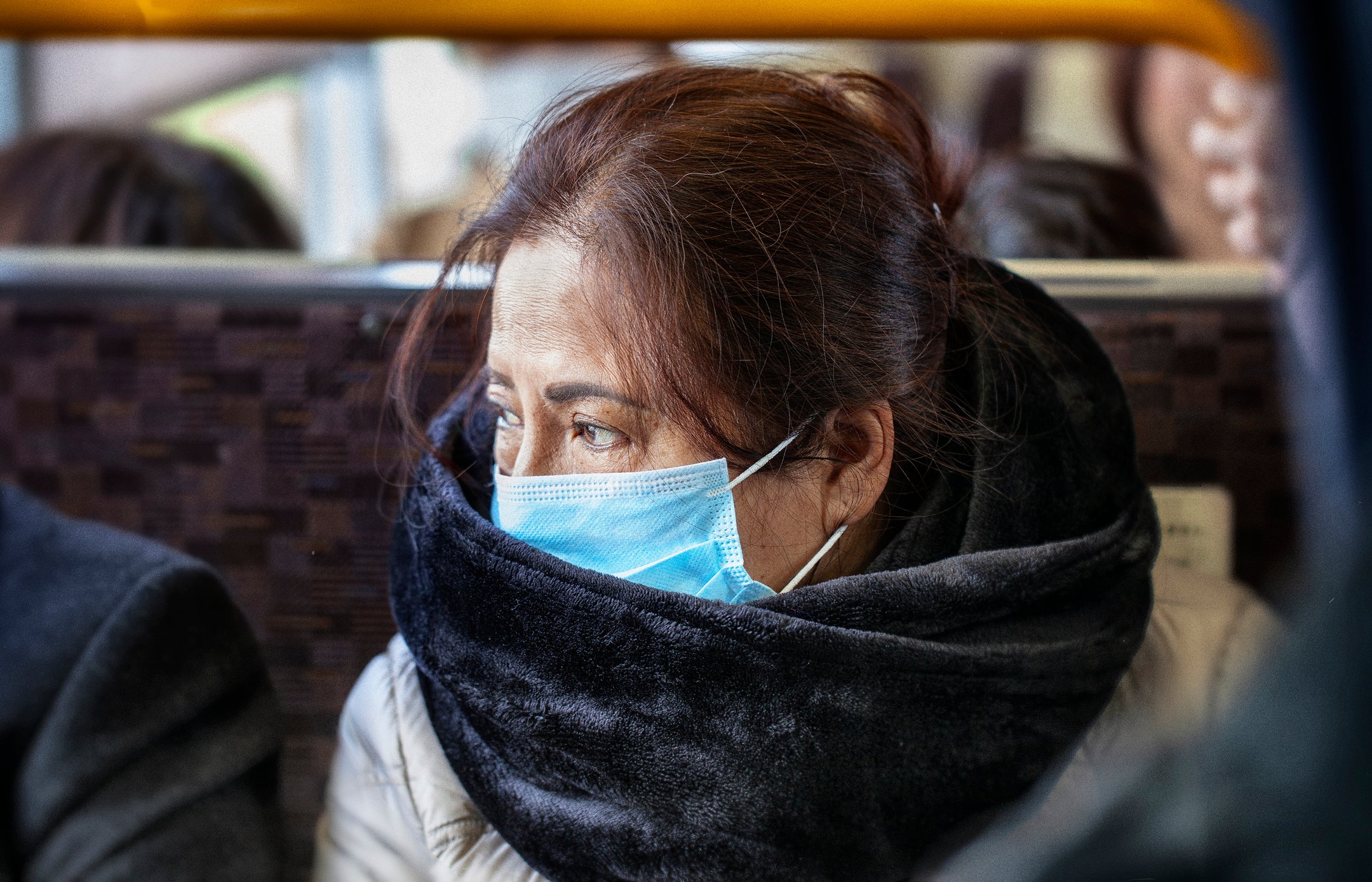 Asian woman wearing surgical mask on a bus