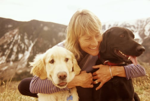Woman hugging her two dogs