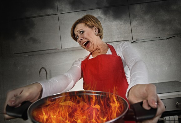 Woman with burning cooking pan