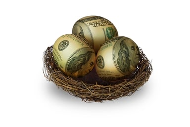 Three eggs painted like money in a nest