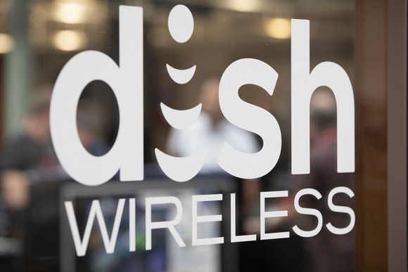 the DISH wireless logo is shown on a glass door outside a store