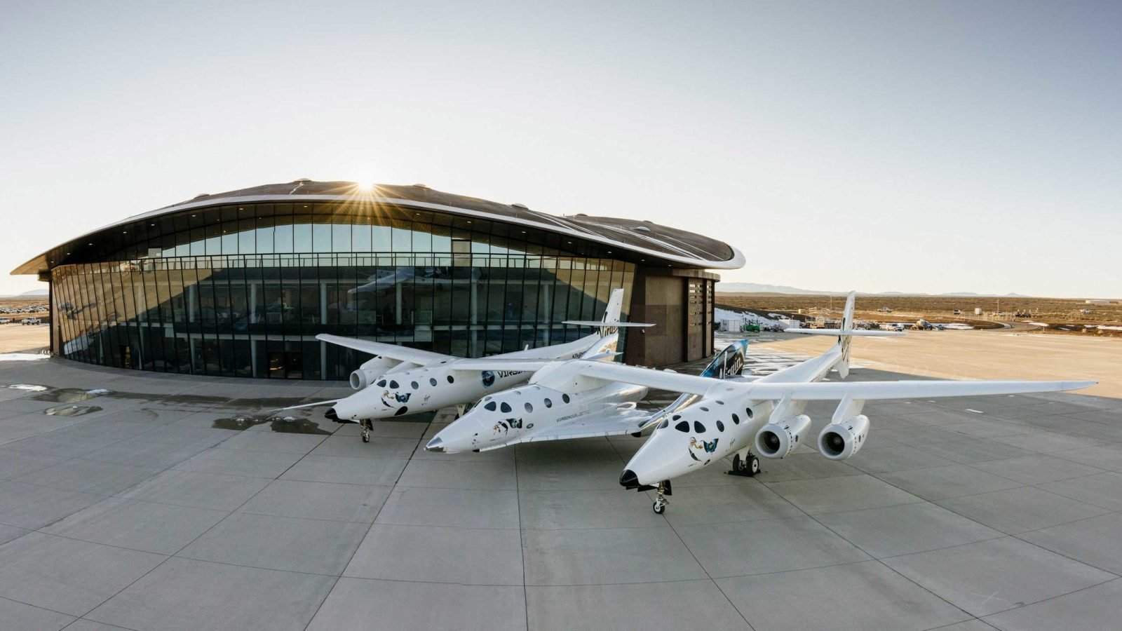 Three Virgin Galactic spacecraft near outside of a hangar