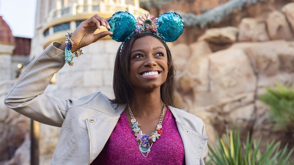 A woman wearing Mickey Mouse ears at a Disney theme park.