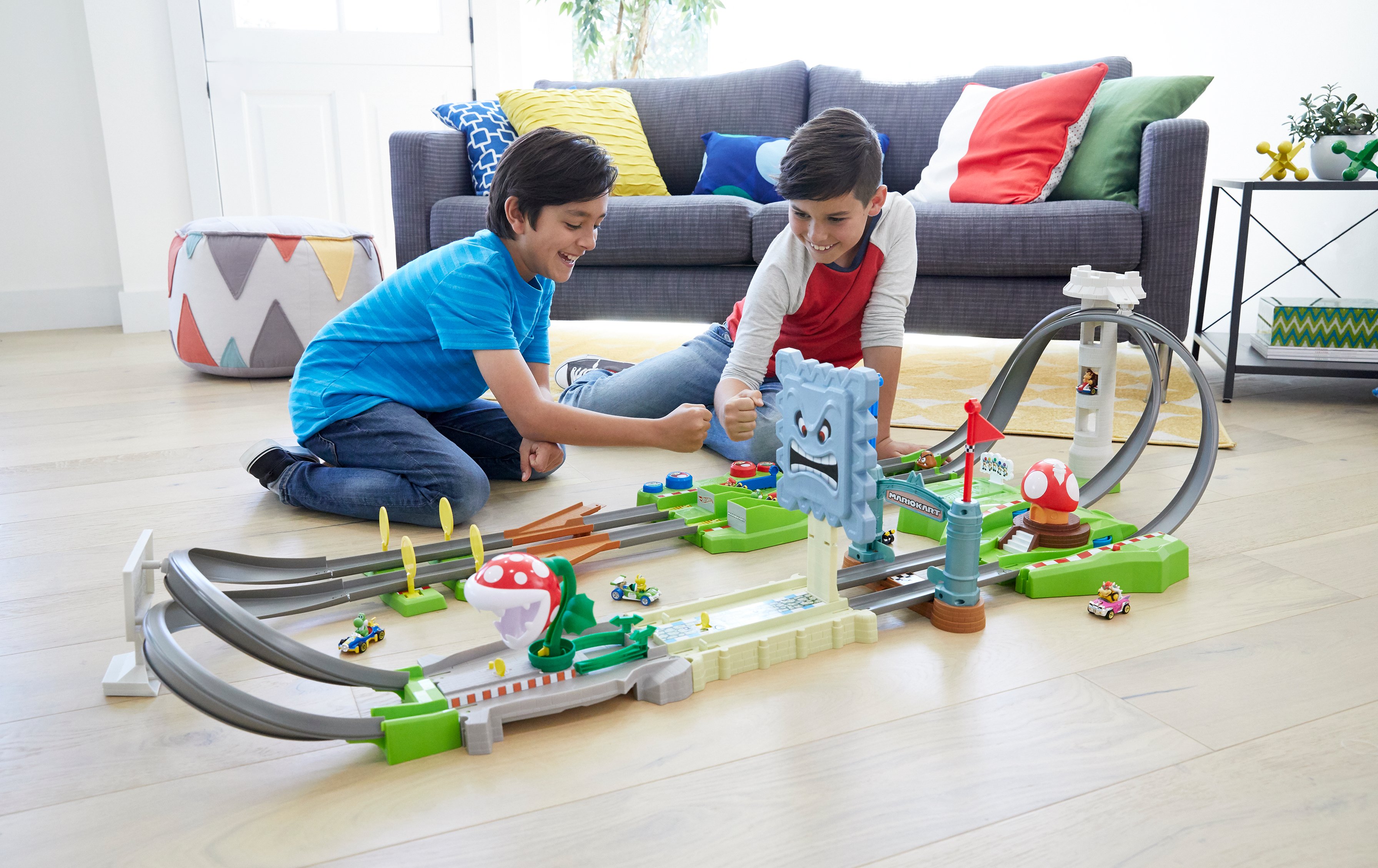 Two boys playing with a track set.