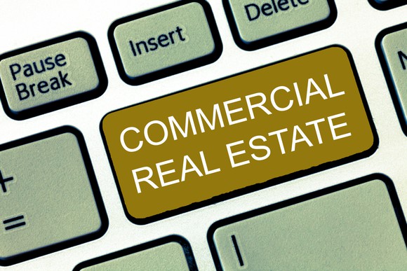 a portion of a computer keyboard is shown with a key on it saying commercial real estate