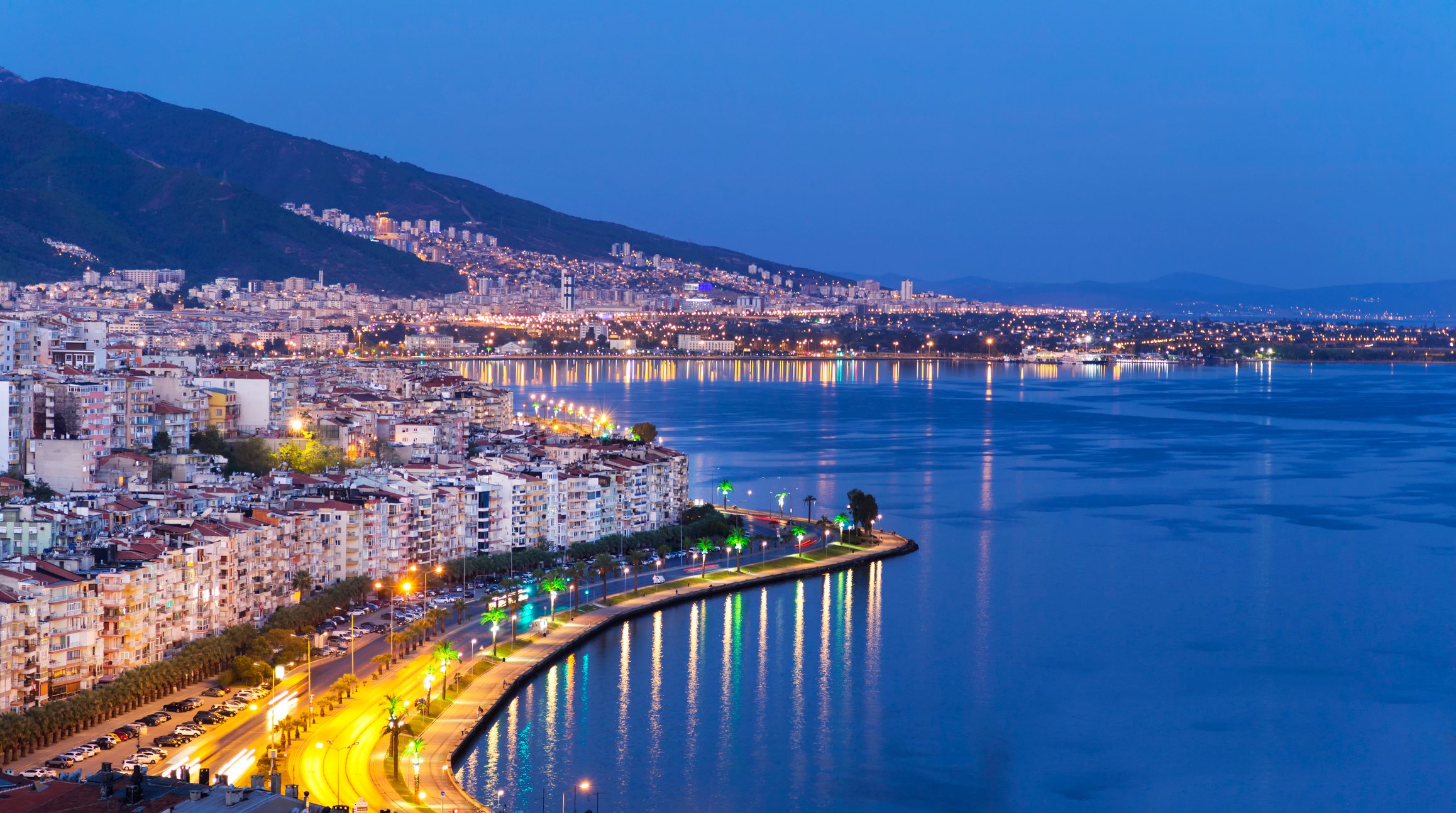 The Izmir skyline overlooking the sea at dusk.