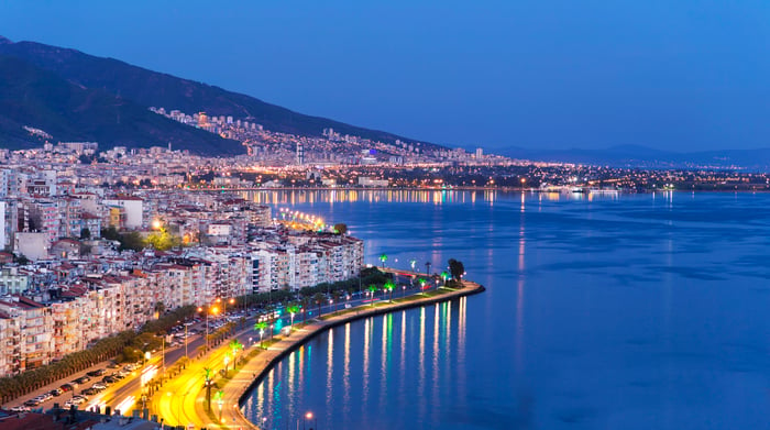 The Izmir skyline overlooking the sea at dusk.