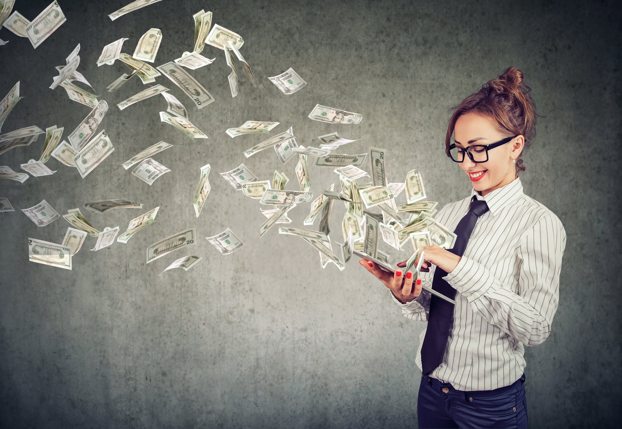 Money flies out of a woman's tablet.