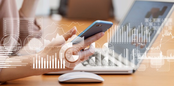 Charts and graphics superimposed over a person using computing devices