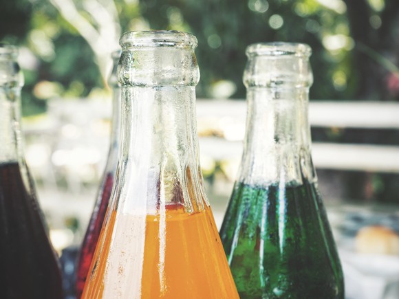 Close-up of glass soda bottles in various flavors.