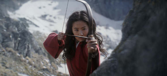 A scene from Disney's "Mulan" showing a woman shooting an arrow.
