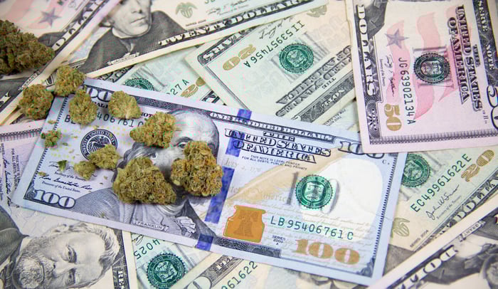Marijuana buds atop a spread of $100 bills.