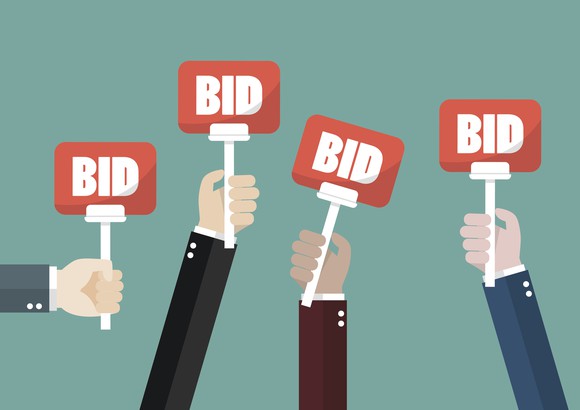 Hands raising bid signs at an auction