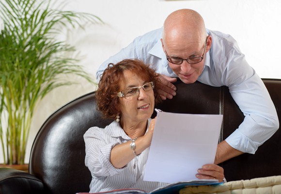 Older couple smiling while checking financial returns