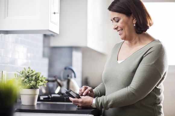 A woman using a device to check her blood glucose levels.