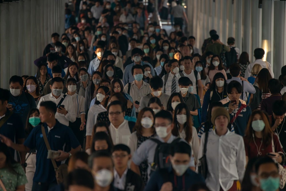 Crowd of people wearing medical facemasks.