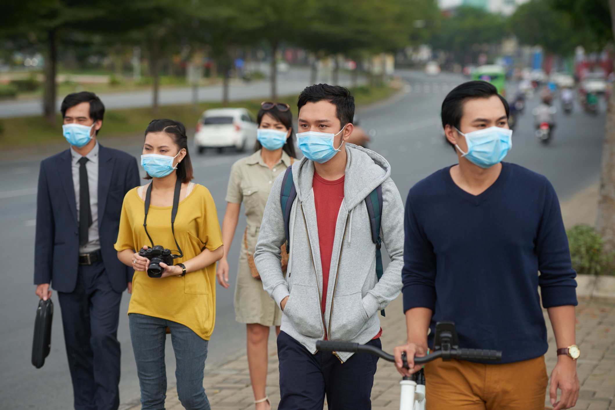 People on the sidewalk wearing masks